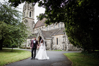 Bride and Groom walk along the drive way leaving St Johns Church